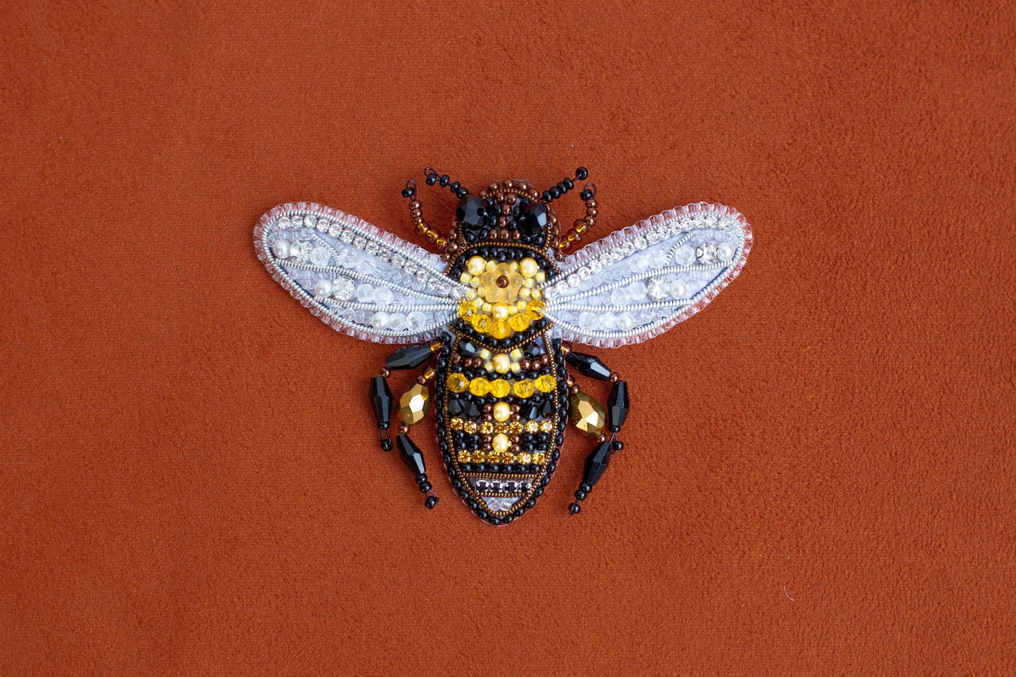 a yellow and black insect sitting on top of a brown surface