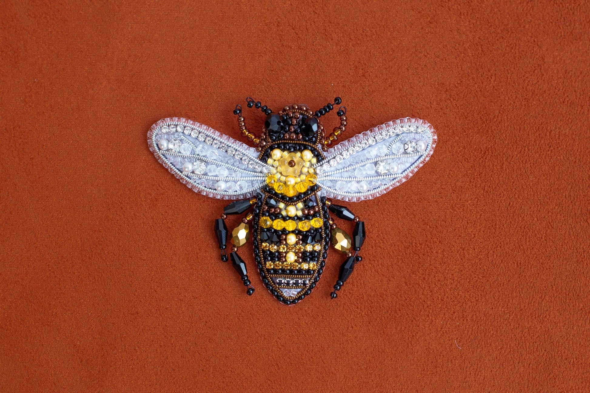 a yellow and black insect sitting on top of a brown surface
