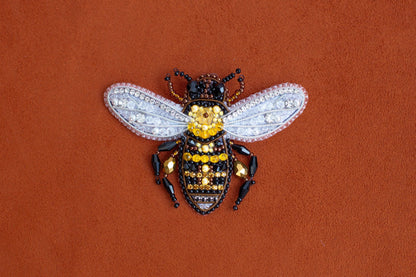 a yellow and black insect sitting on top of a brown surface