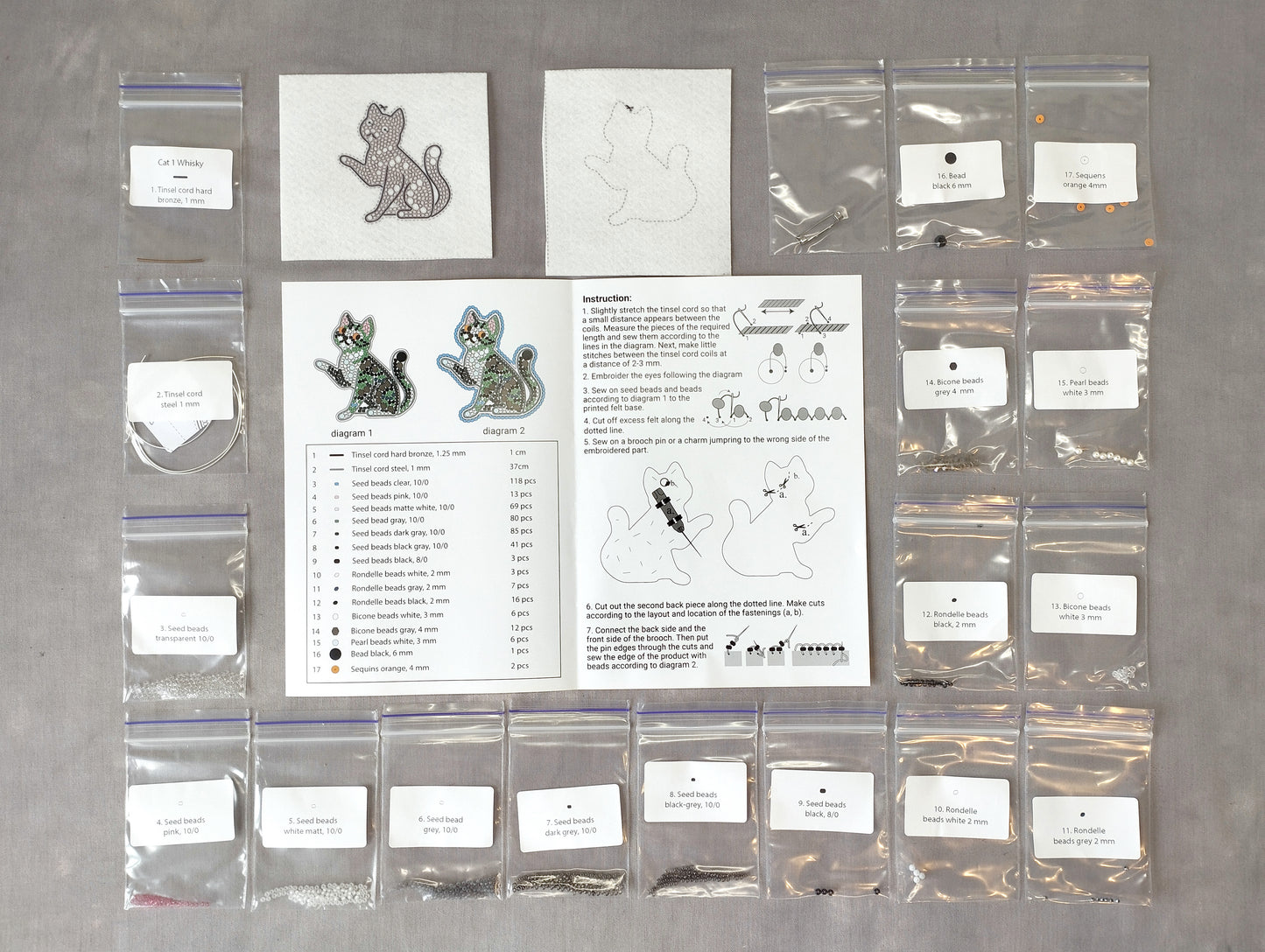 various craft supplies and materials, including bags of beads, a book with instructions, and a pattern for creating cat-shaped earrings.