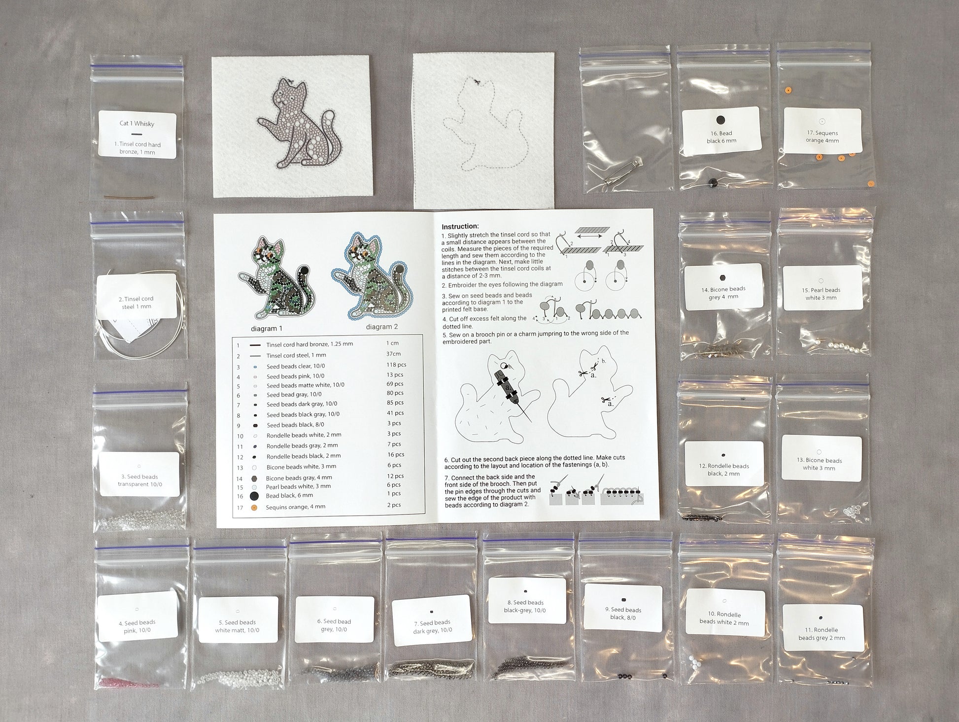 various craft supplies and materials, including bags of beads, a book with instructions, and a pattern for creating cat-shaped earrings.