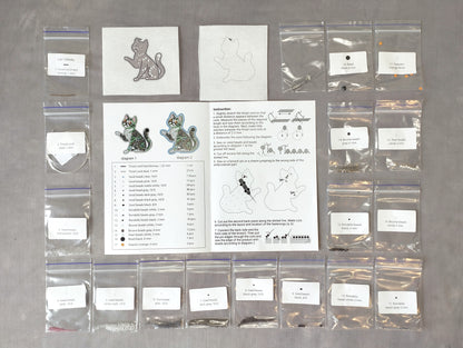 various craft supplies and materials, including bags of beads, a book with instructions, and a pattern for creating cat-shaped earrings.