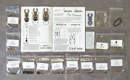 various craft supplies and materials, including bags of beads, a diagram, and instructions, all arranged on a table.