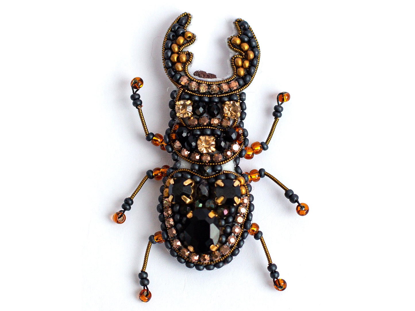 a bug made of beads and beads on a white surface