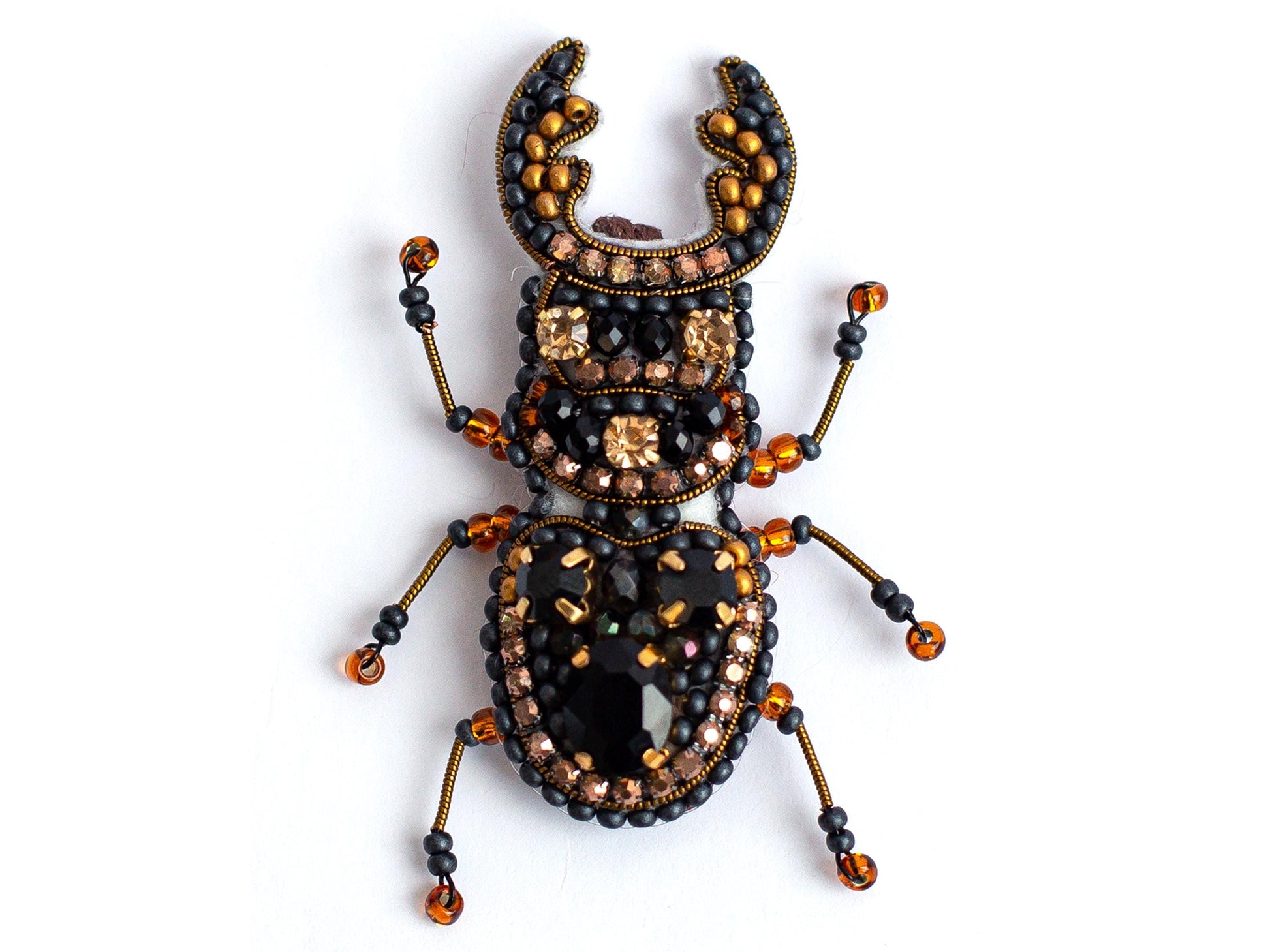 a bug made of beads and beads on a white surface