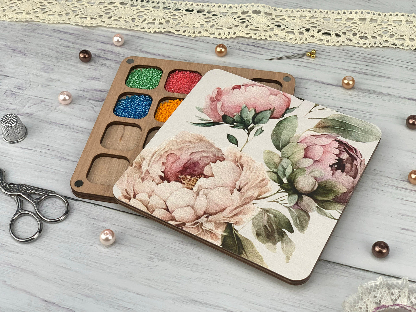a wooden box with a flower design on it next to a pair of scissors