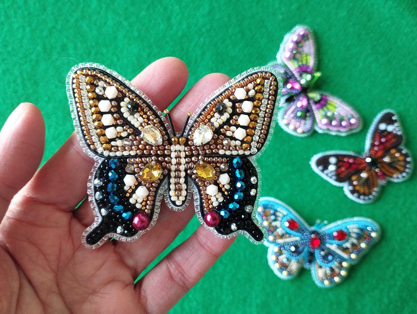 a person holding a small butterfly in their hand