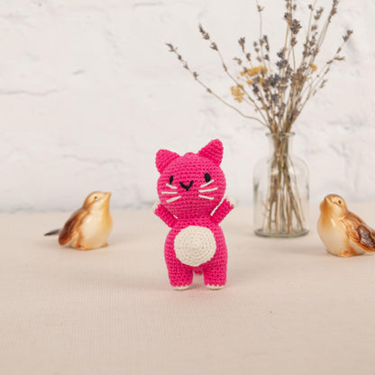 a crocheted cat and two birds are next to a vase with flowers