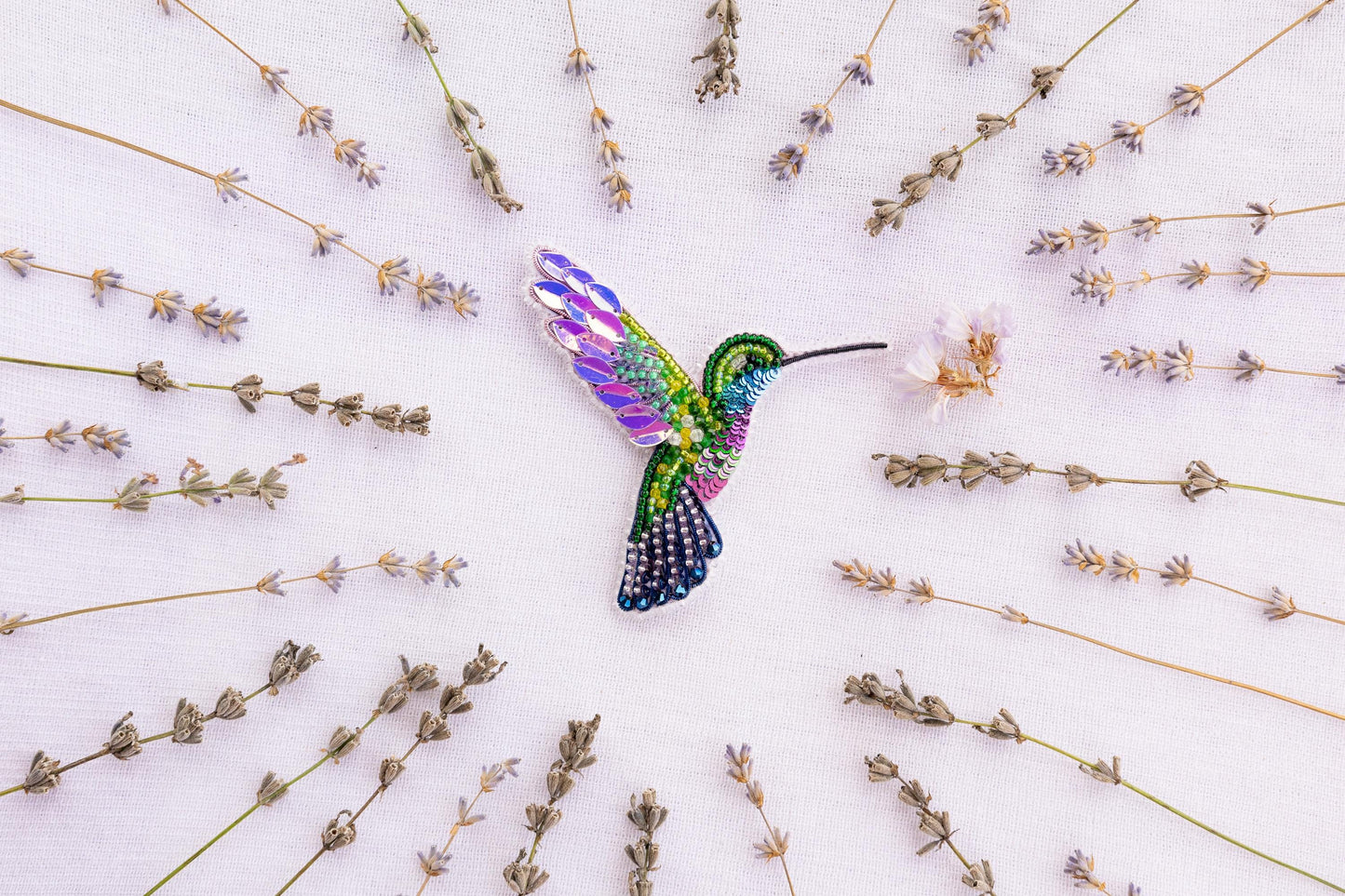 a colorful hummingbird flying over a field of flowers