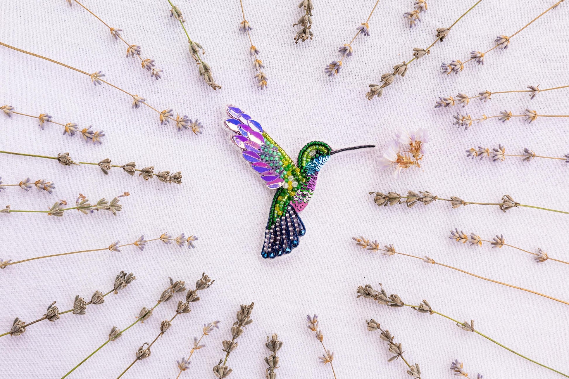 a colorful hummingbird flying over a field of flowers