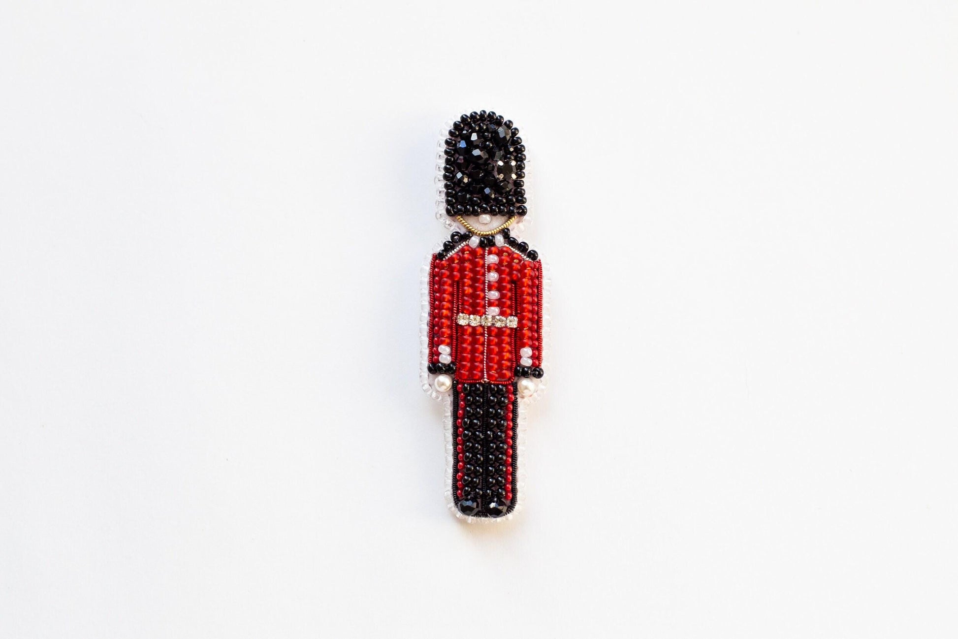 a beaded figure of a man in a red uniform