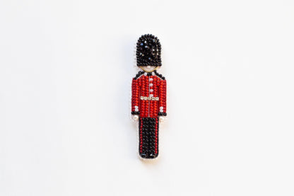 a beaded figure of a man in a red uniform
