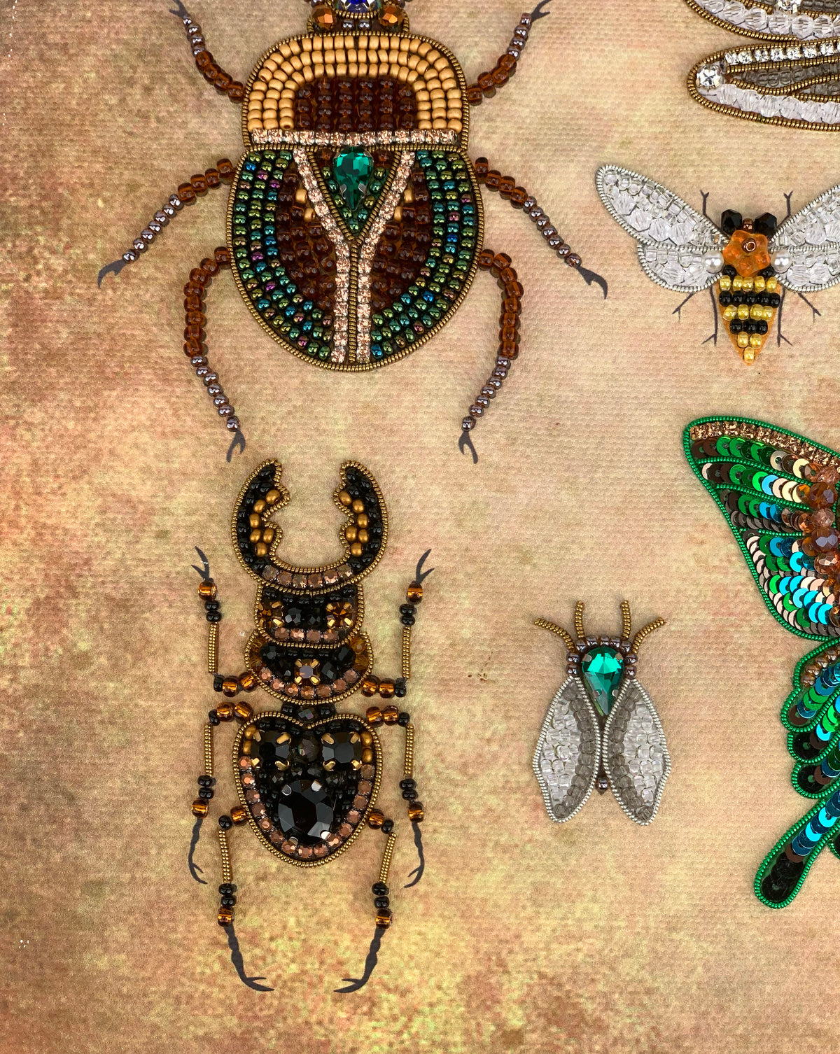 a collection of intricately designed insects, including a large beetle, a bee, and a butterfly, all adorned with colorful beads and jewels.