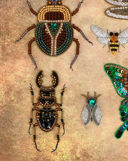 a collection of intricately designed insects, including a large beetle, a bee, and a butterfly, all adorned with colorful beads and jewels.