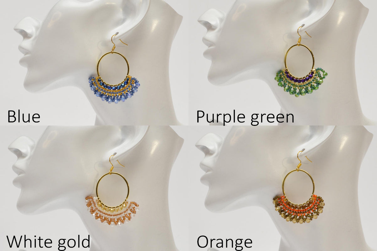 a group of four different colored earrings on a white mannequin