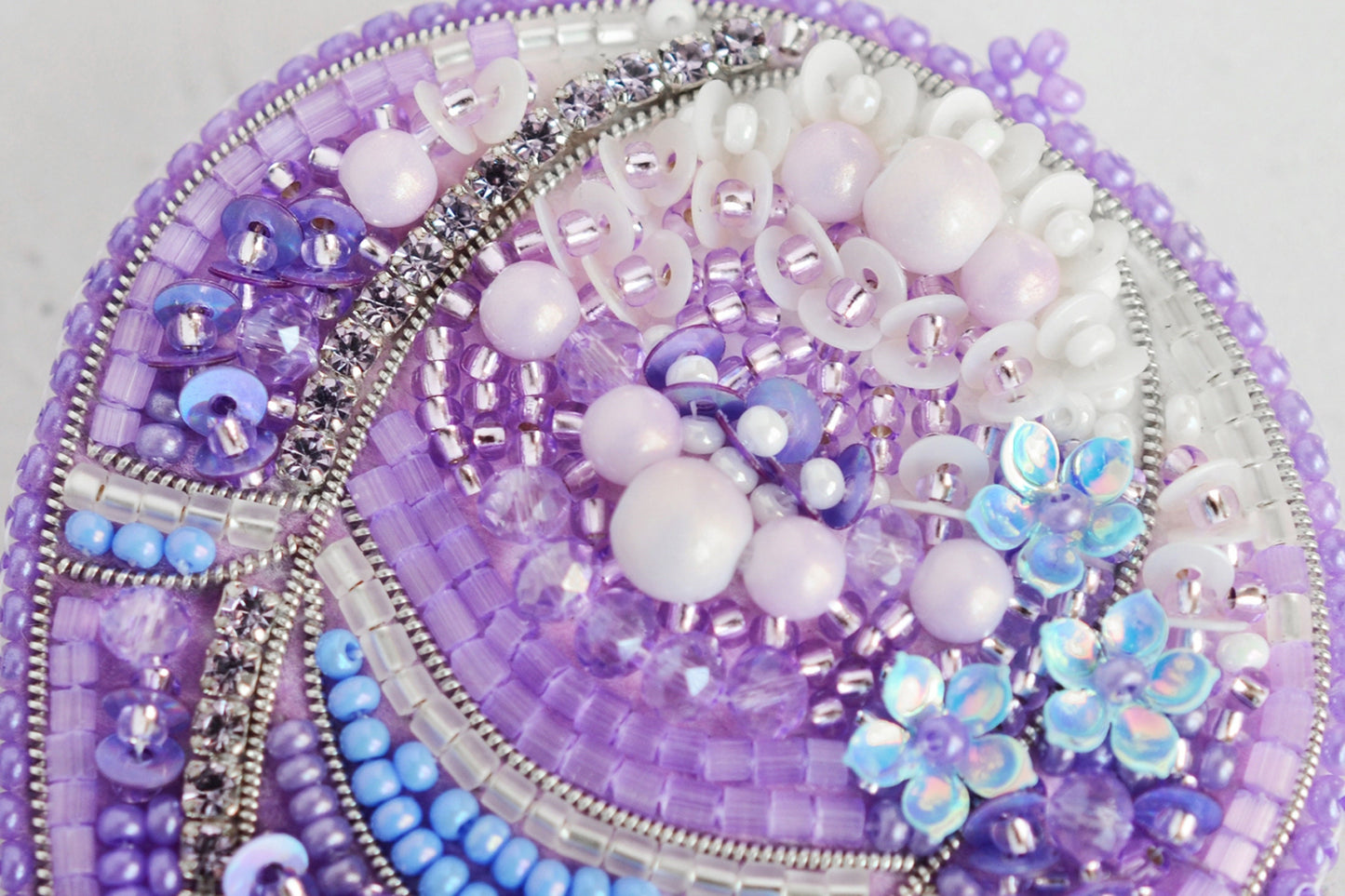 a close up of a purple and white beaded object
