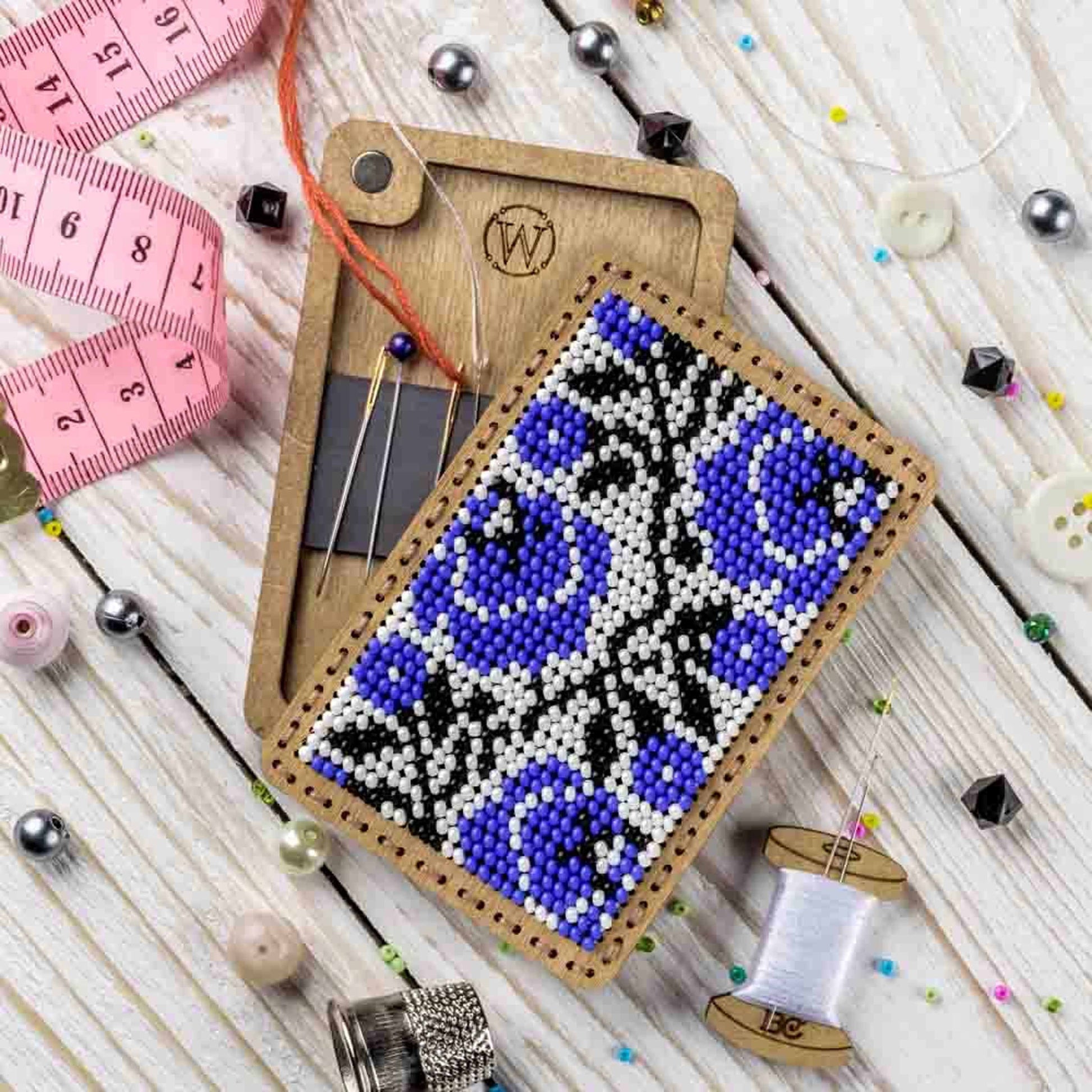 a piece of beaded art next to a measuring tape