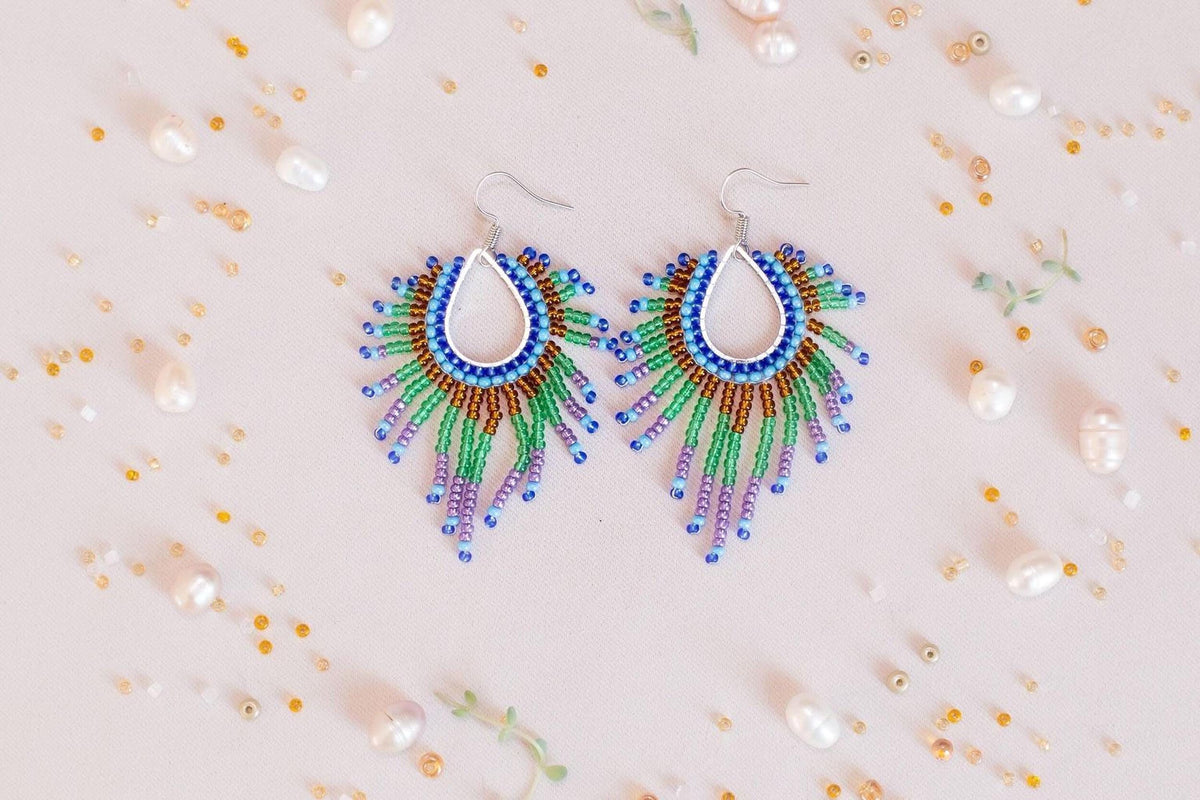 a pair of colorful beaded earrings sitting on top of a table