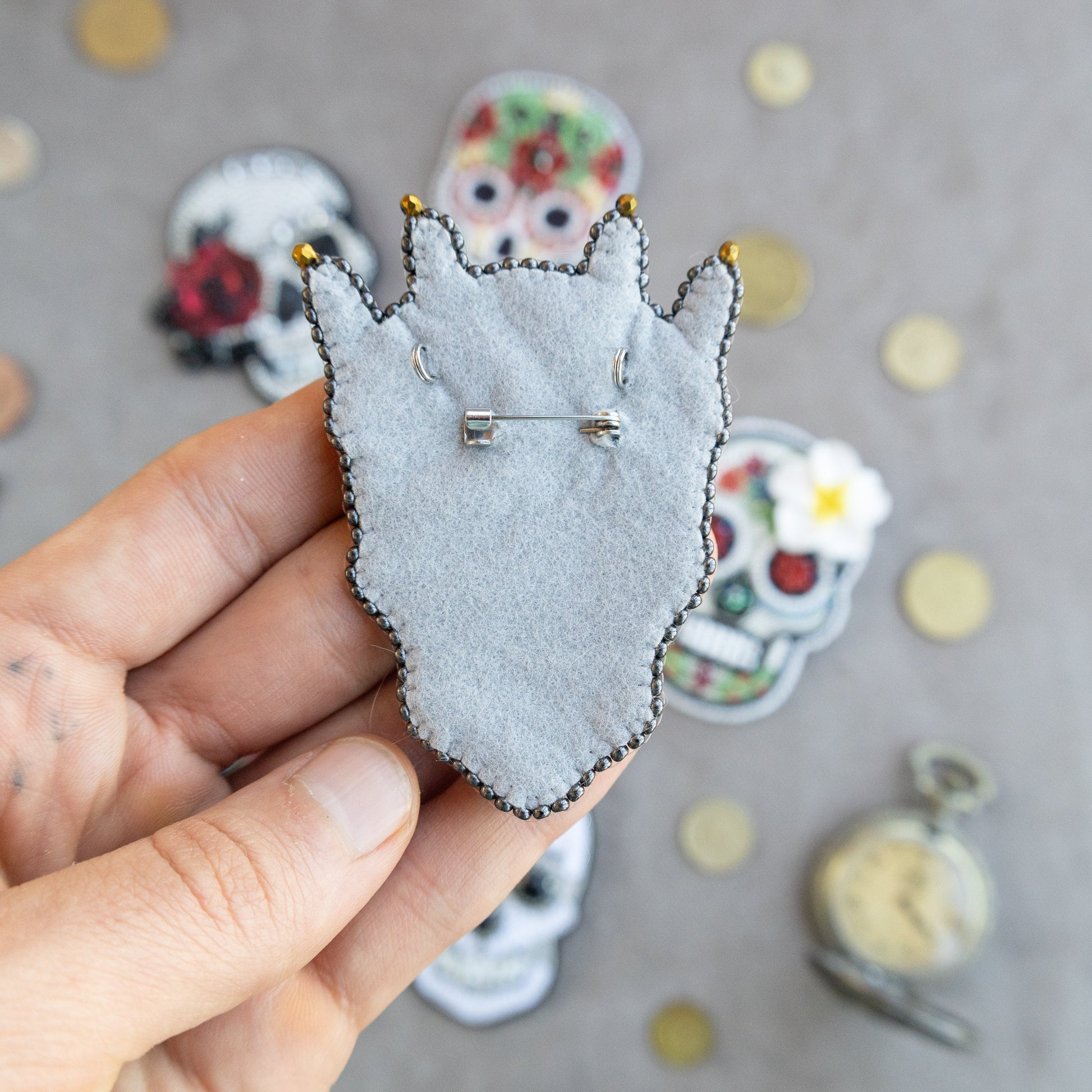 a person holding a pin with a cat on it