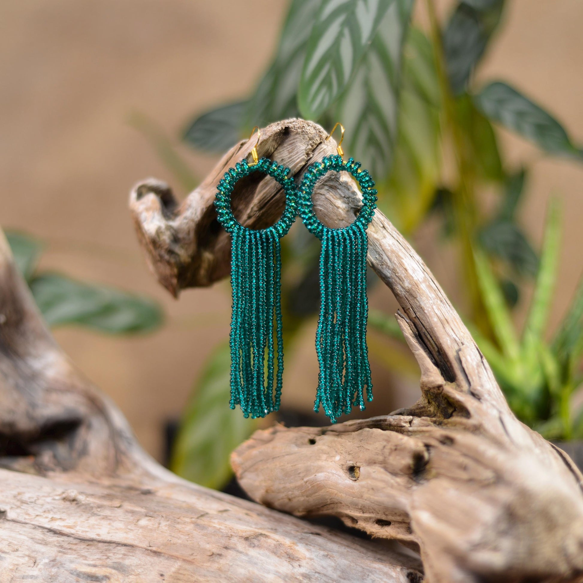 a close up of a pair of green beaded earrings