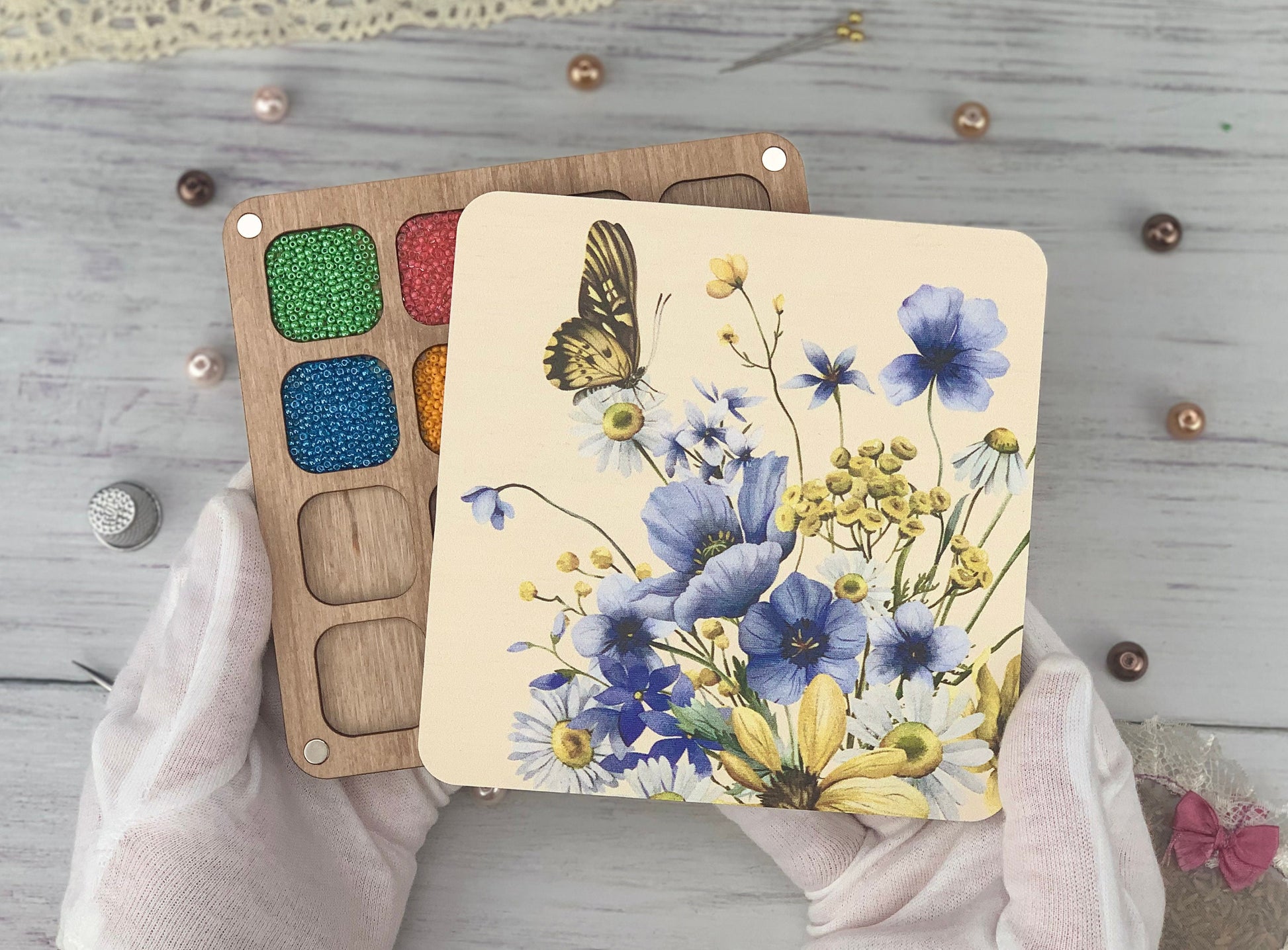 a person's hands holding a paint palette and a painting card