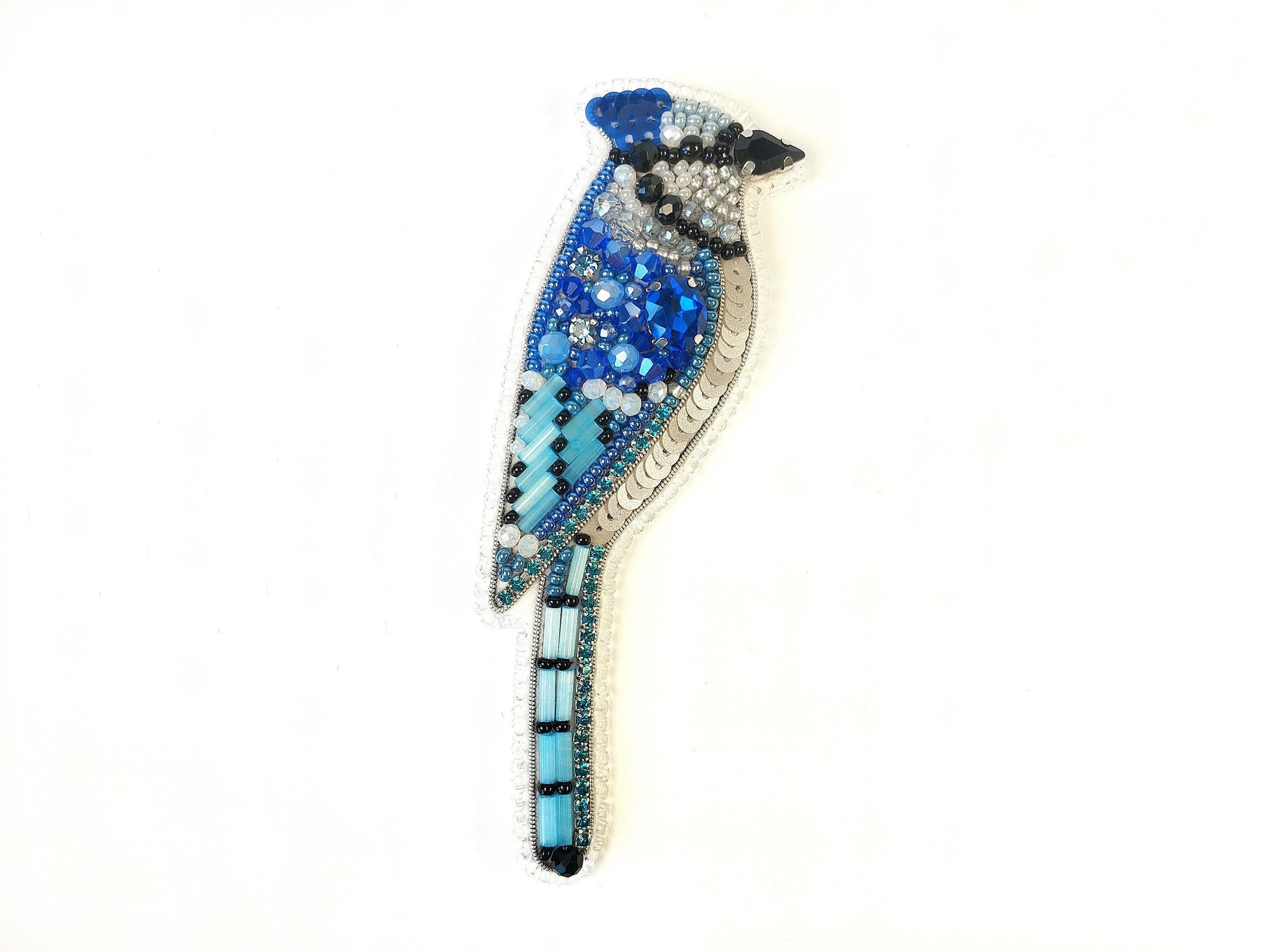 a blue bird brooch sitting on top of a white surface
