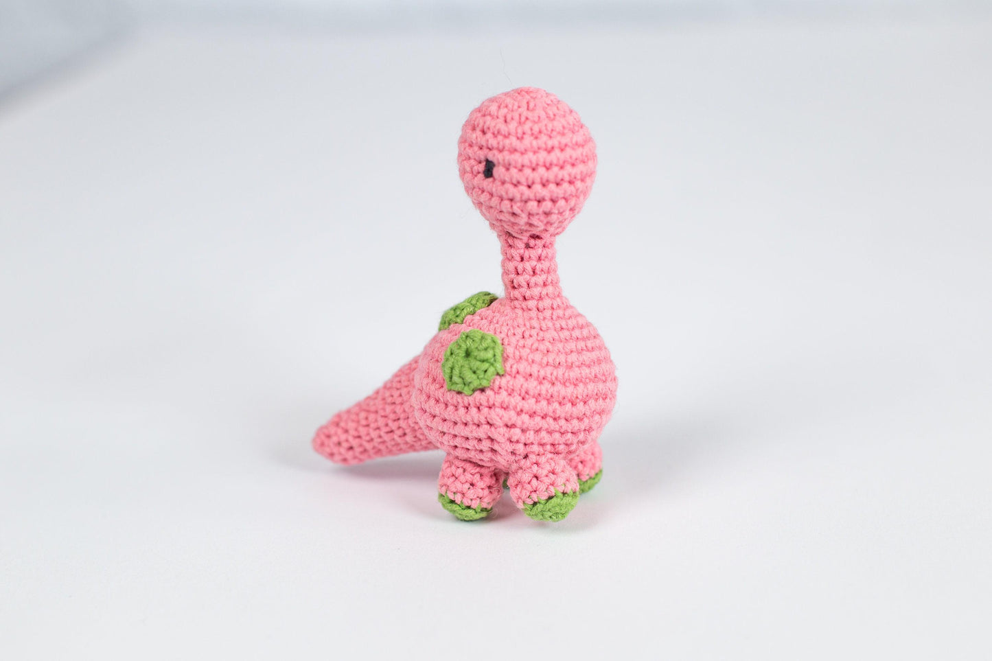 a pink crocheted toy with a green turtle on it&#39;s back