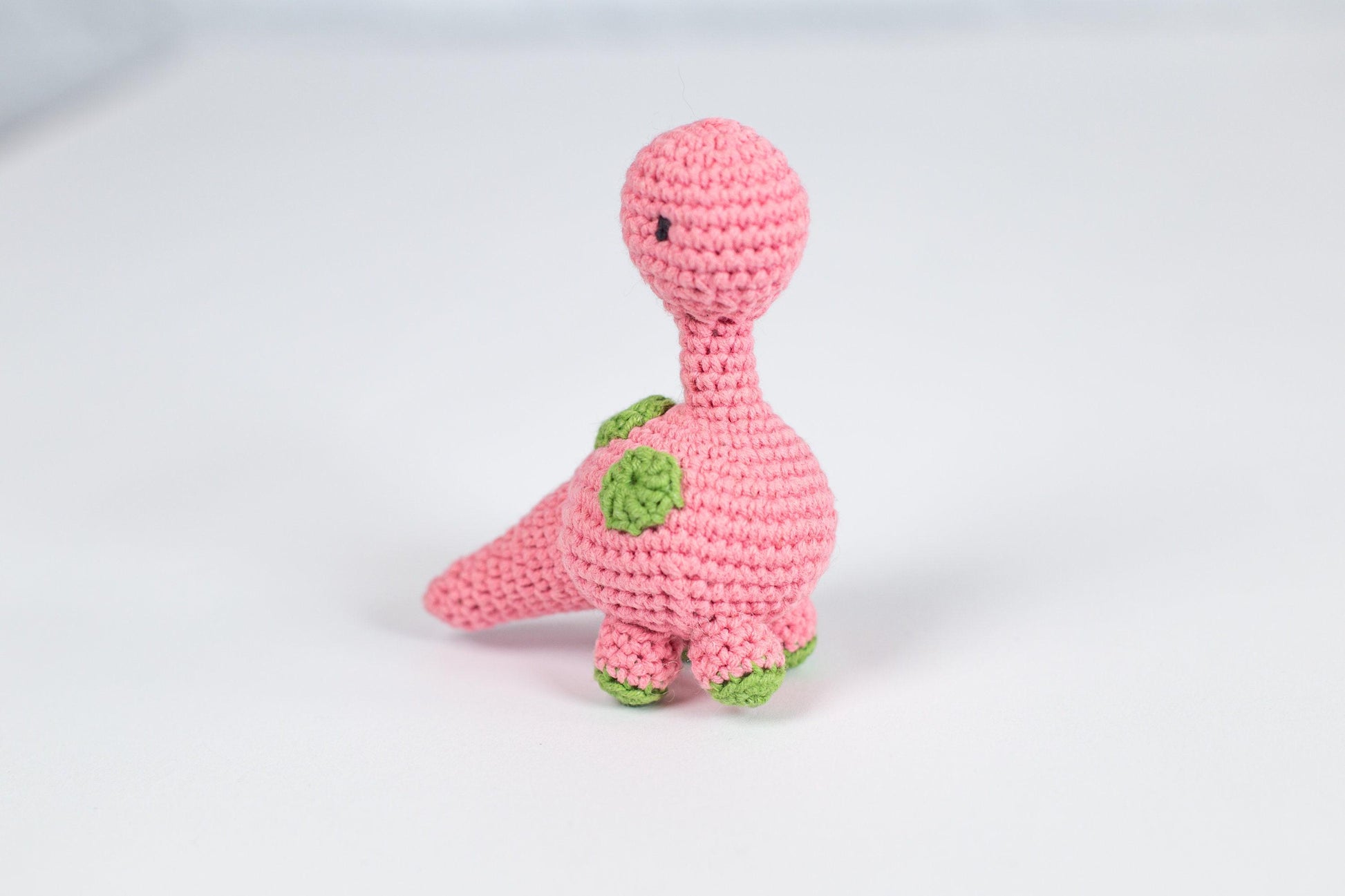 a pink crocheted toy with a green turtle on it&#39;s back