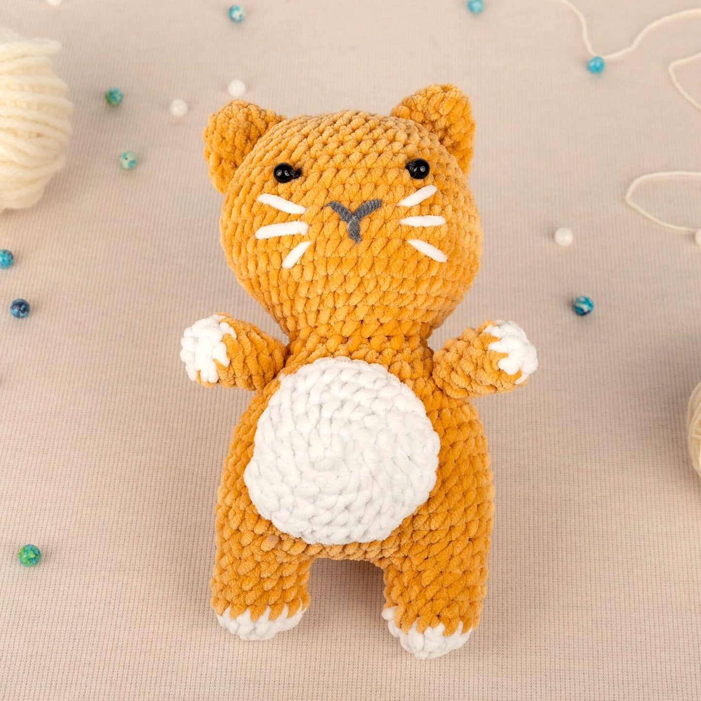 a crocheted cat sitting on top of a table