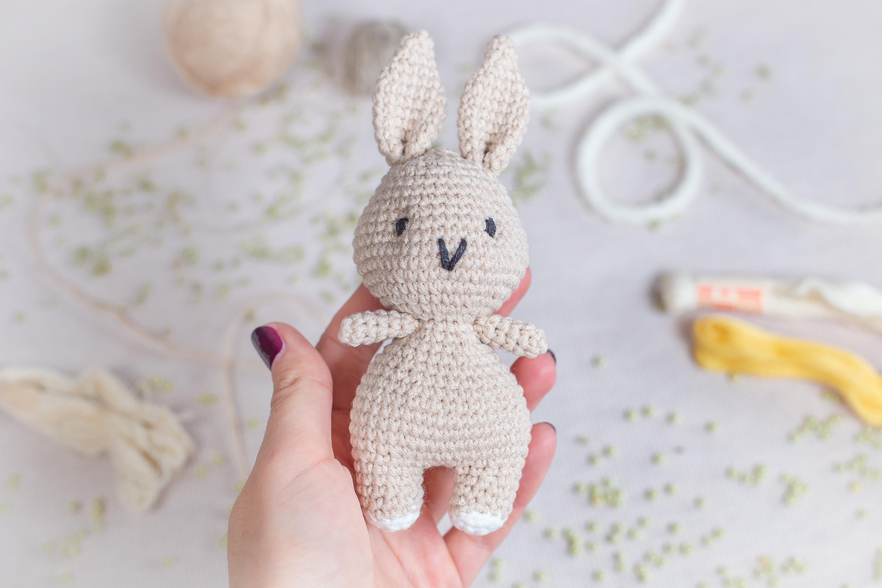 a hand holding a small crocheted bunny