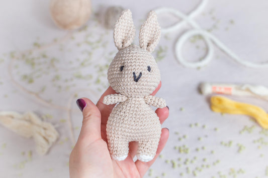 a hand holding a small crocheted bunny
