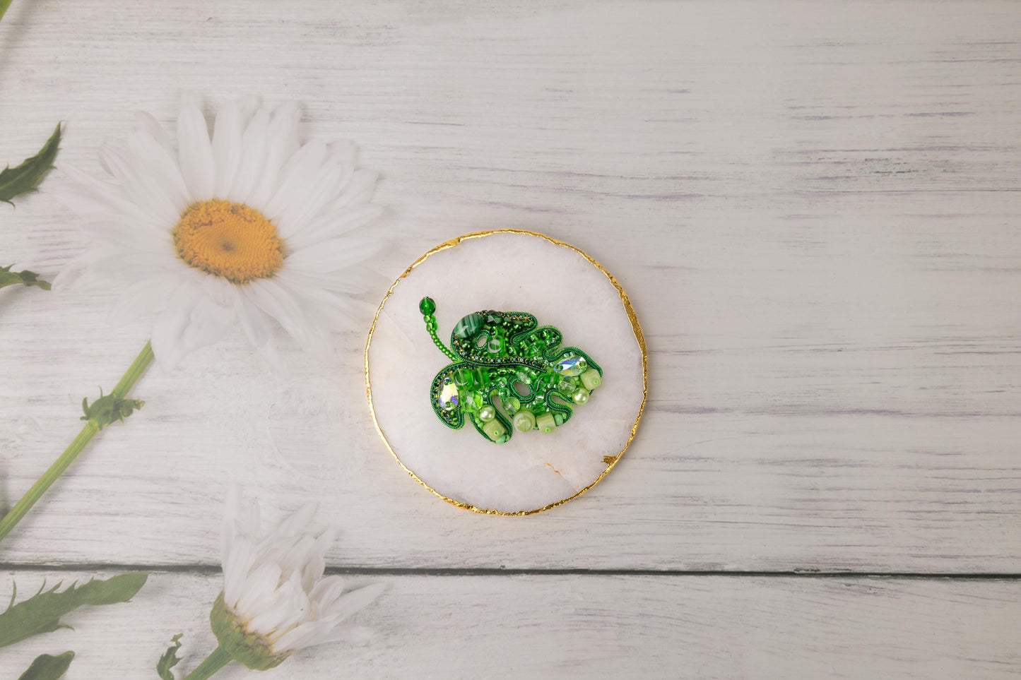 a plate with a green broccoli on it next to a flower
