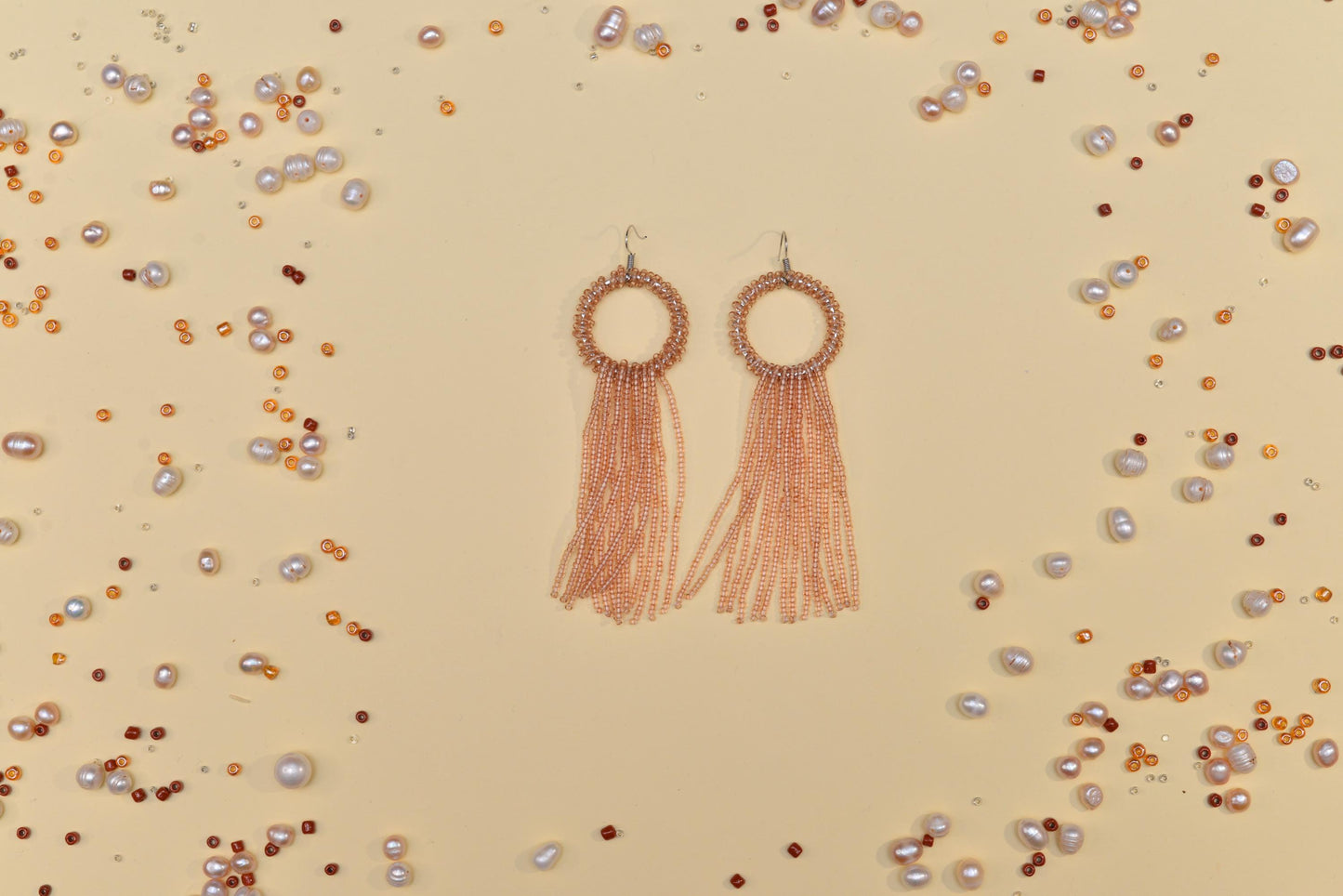 a pair of earrings with tassels and pearls