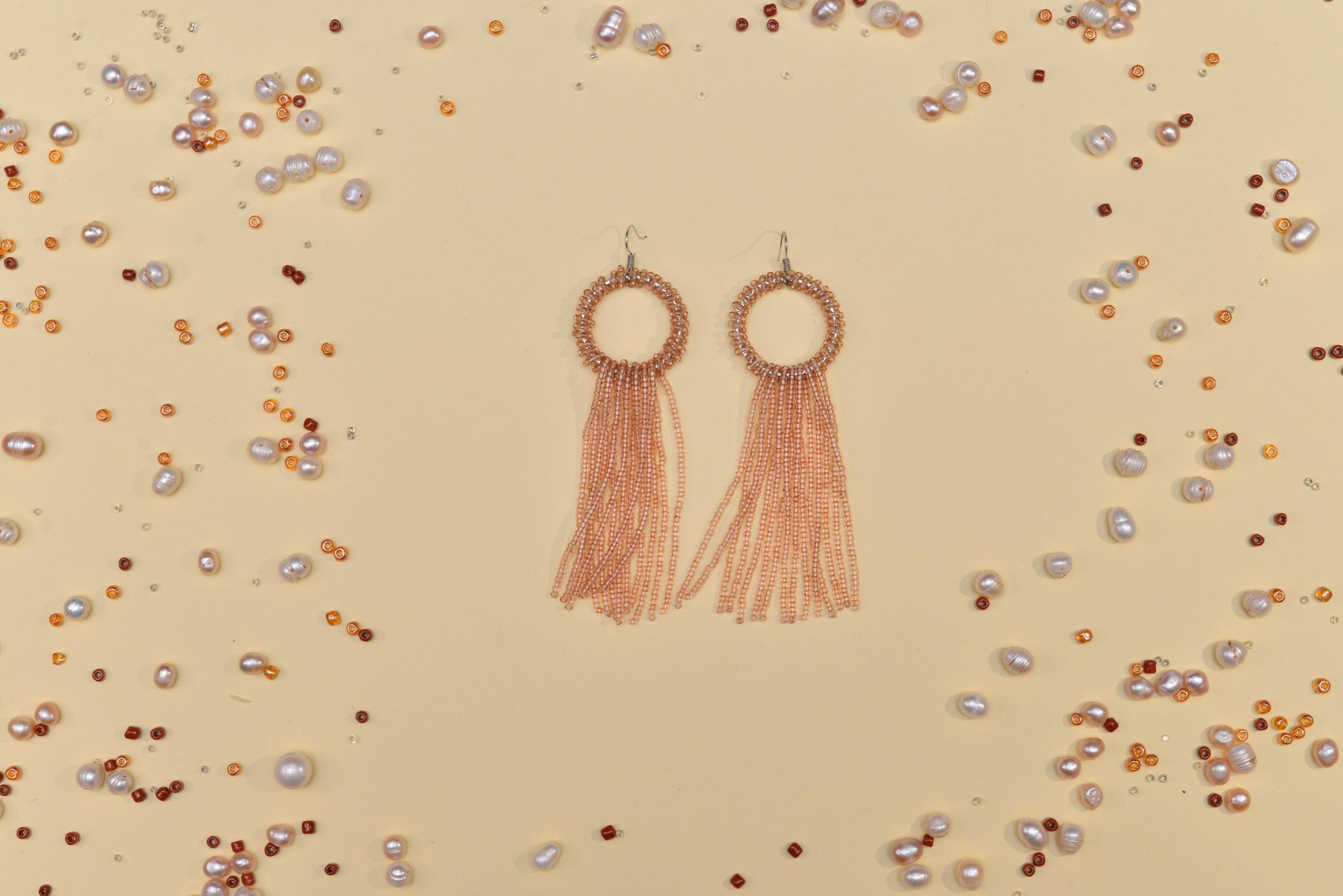 a pair of earrings with tassels and pearls