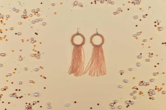 a pair of earrings with tassels and pearls