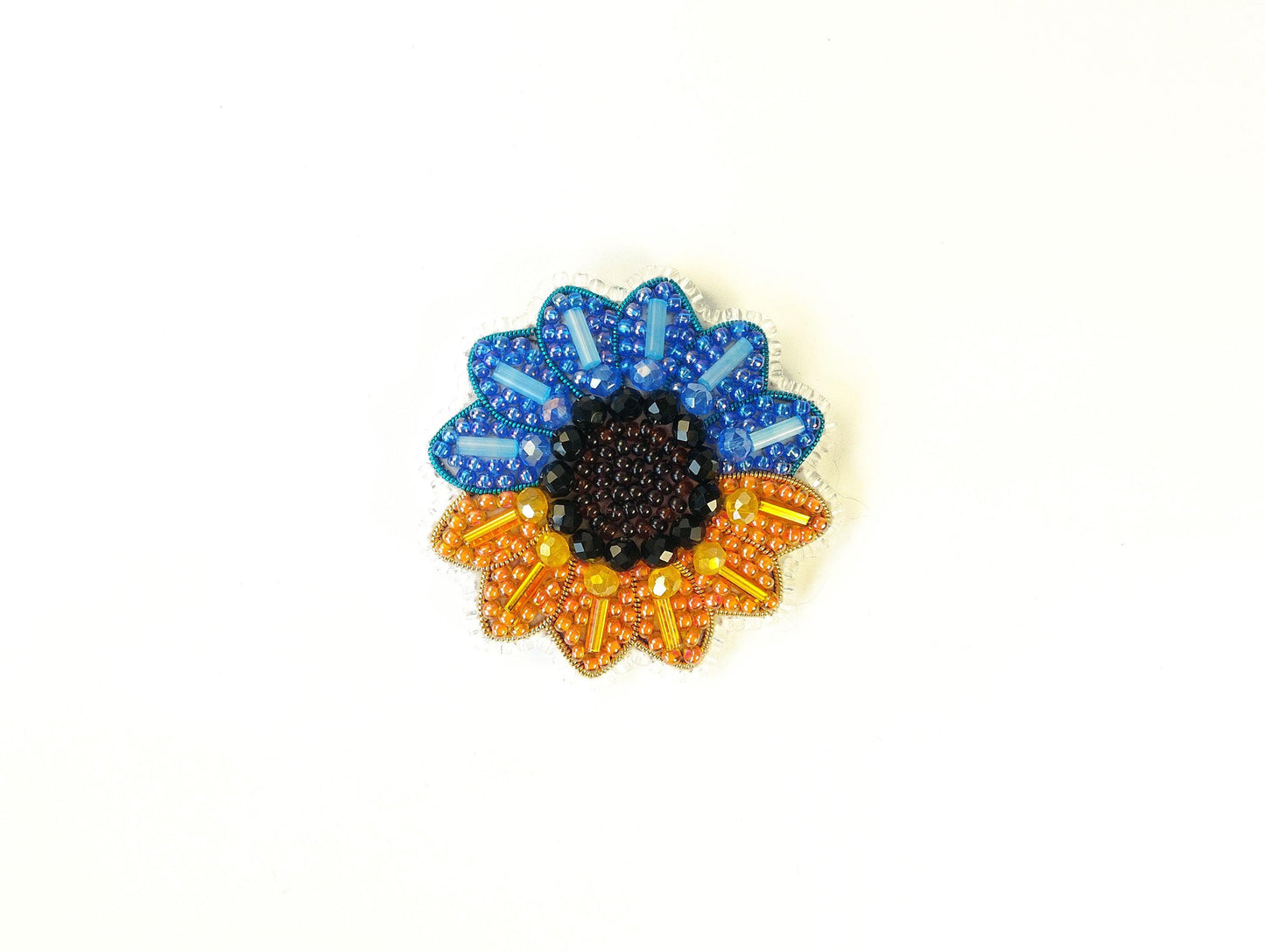 A colorful beaded flower-shaped object with blue, orange, and black beads.