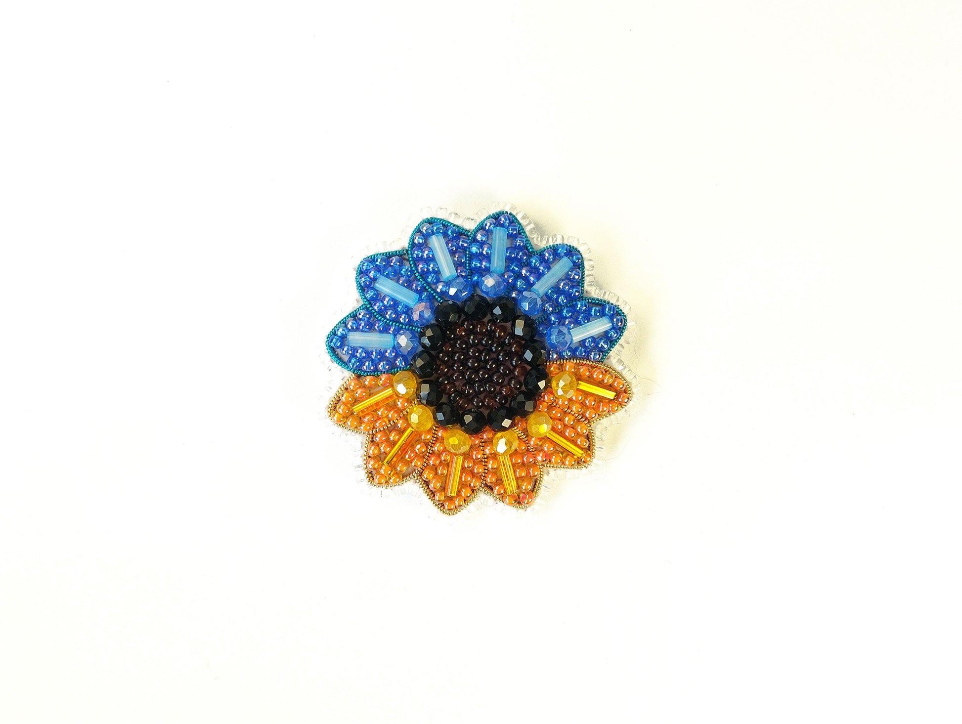 A colorful beaded flower-shaped object with blue, orange, and black beads.