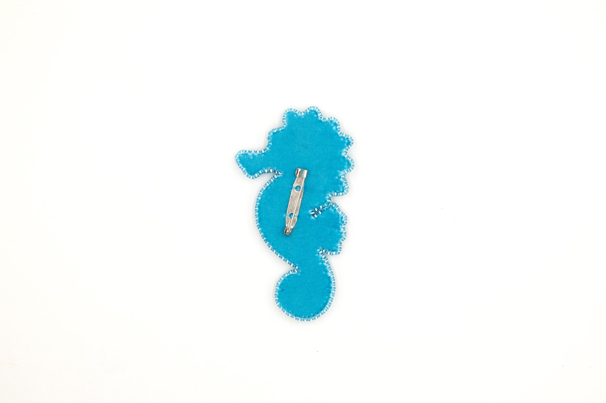 a blue seahorse is on a white surface