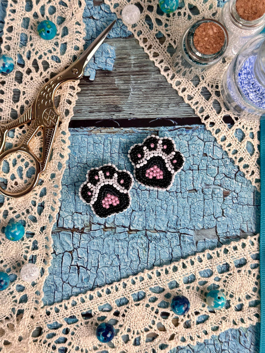 a pair of black and pink paw prints on a piece of lace
