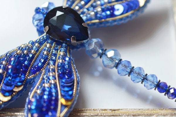 a close up of a blue and gold brooch