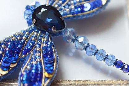 a close up of a blue and gold brooch