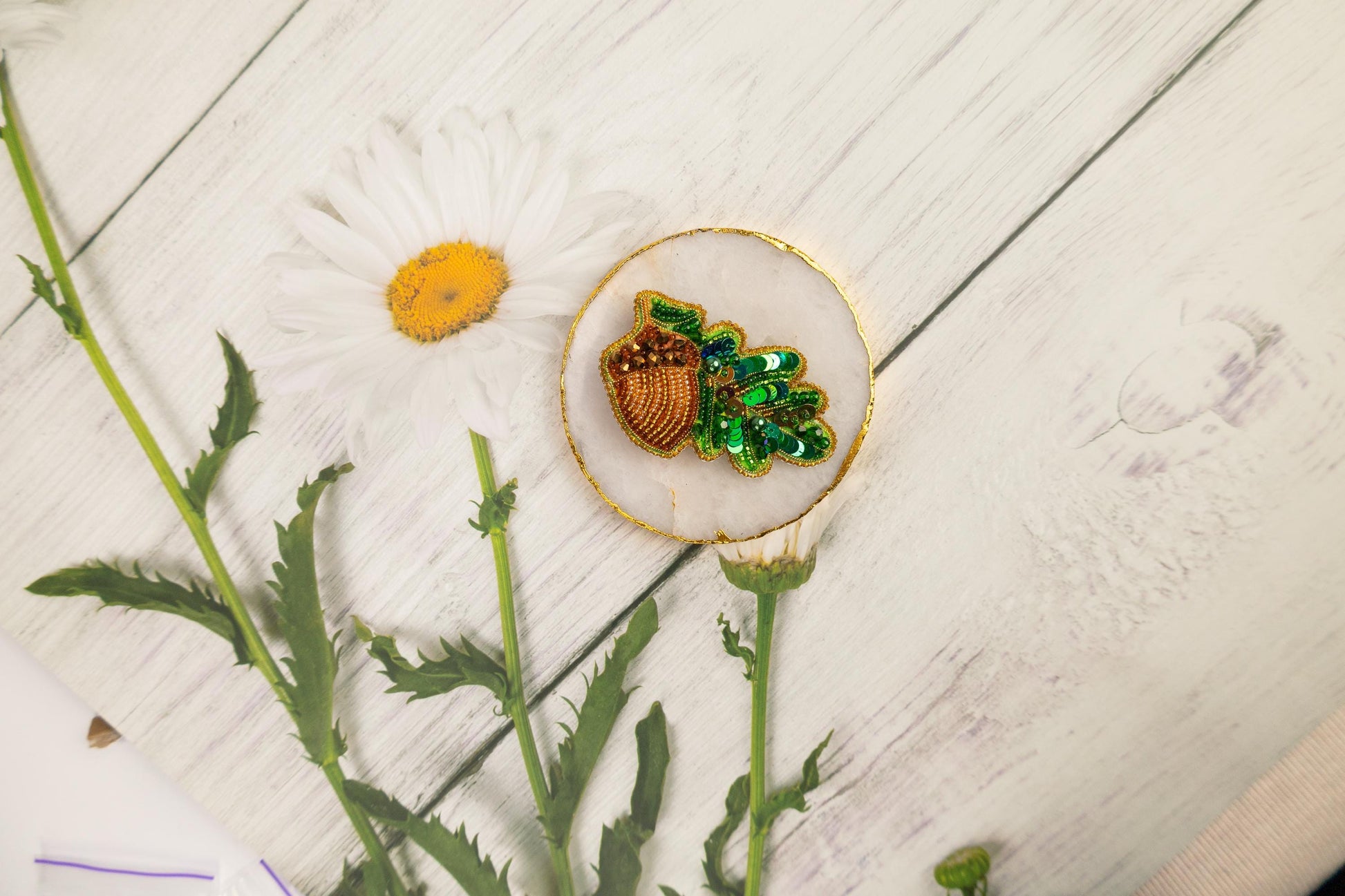 a flower and a brooch sitting on a table
