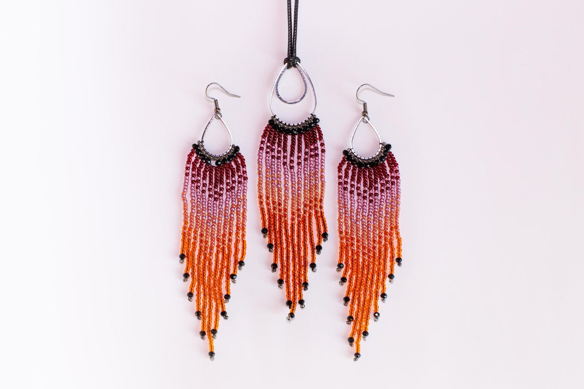 a set of three beaded earrings and a necklace with a gradient of orange and purple beads.