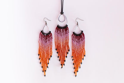 a set of three beaded earrings and a necklace with a gradient of orange and purple beads.