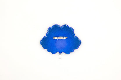 a blue brooch with a ring on it