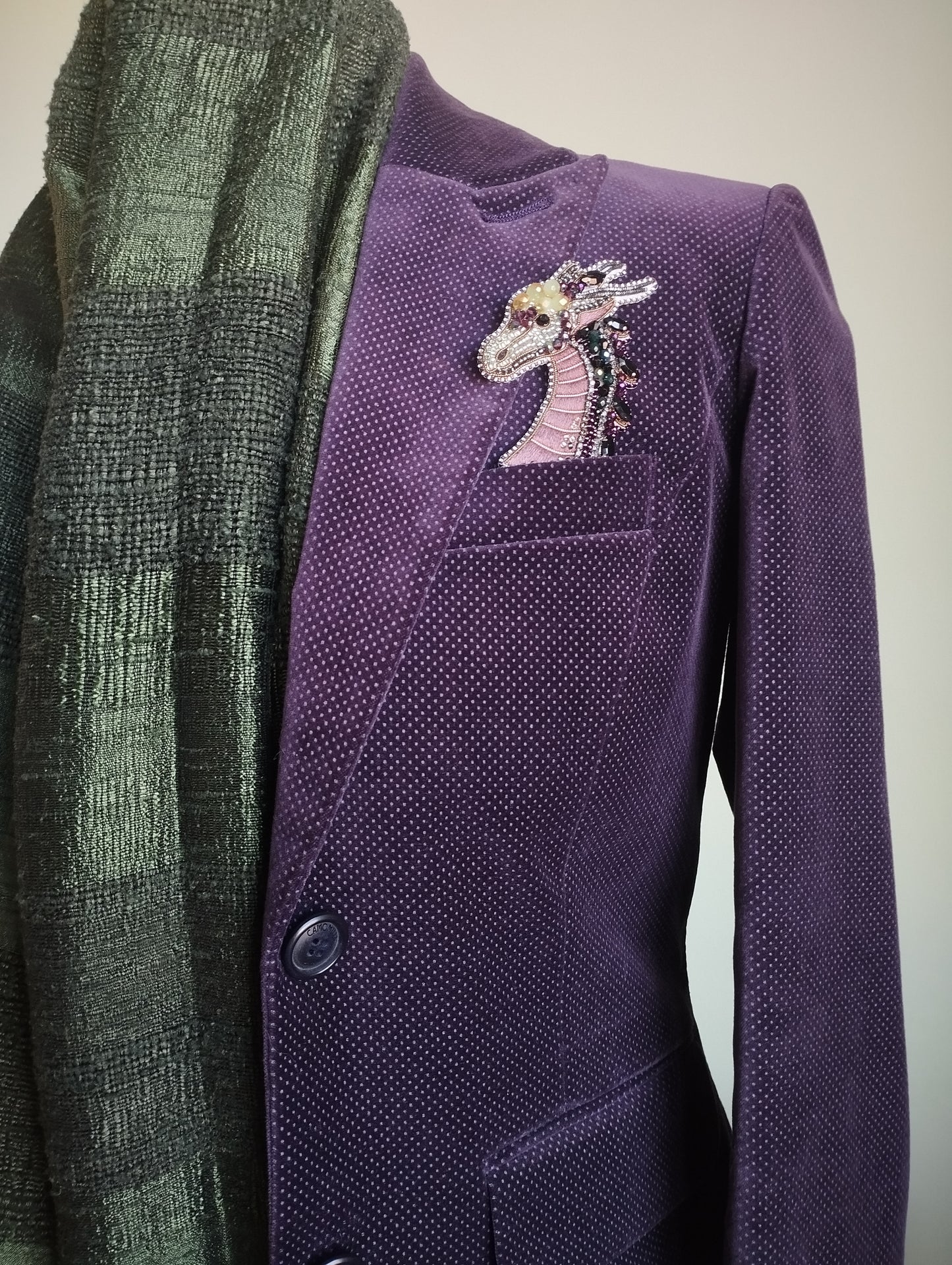 a purple jacket with a decorative dragon embroidered on the left side of the chest.