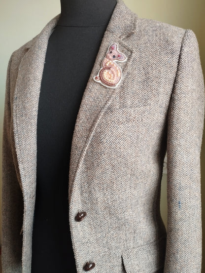 A gray tweed jacket with a small embroidered cat design on the left breast pocket area.
