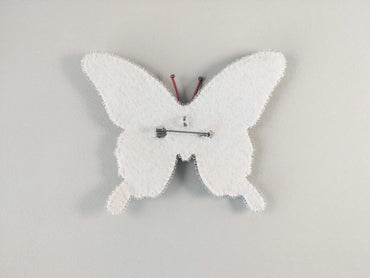 a white clock with a butterfly design on it