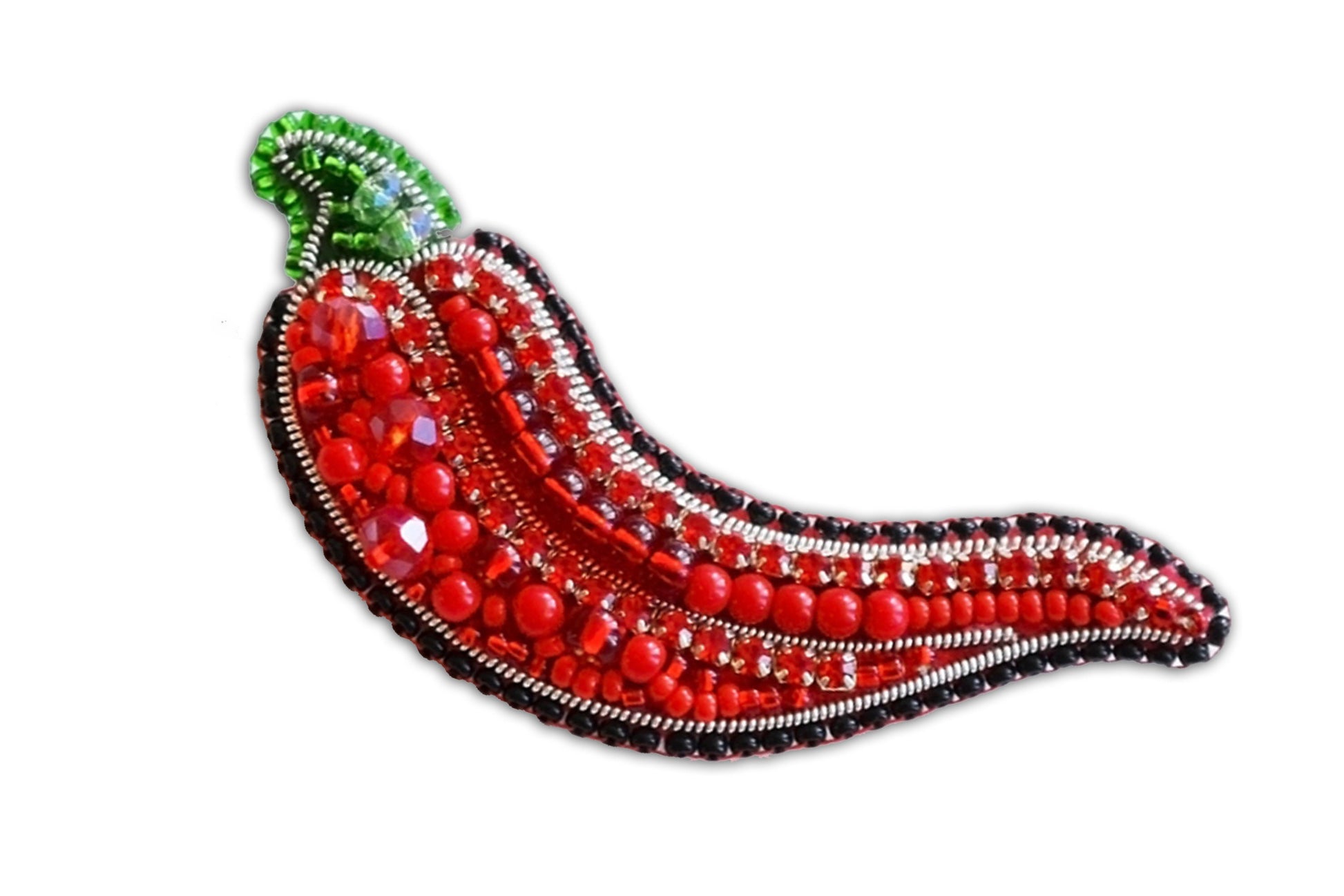 a red beaded brooch sitting on top of a white surface