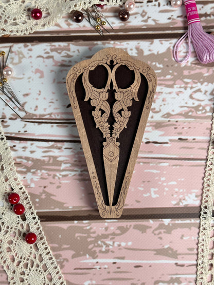 a pair of scissors sitting on top of a piece of wood